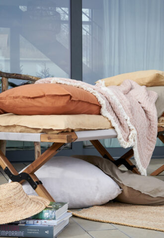 Lit extérieur avec coussins et couvertures cosy.