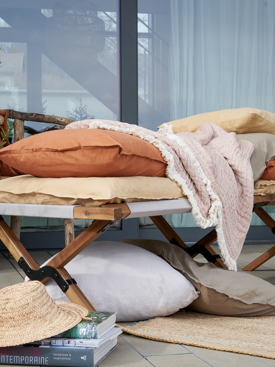 Lit extérieur avec coussins et couvertures cosy.