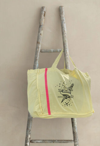 Sac jaune suspendu à une échelle en bois.