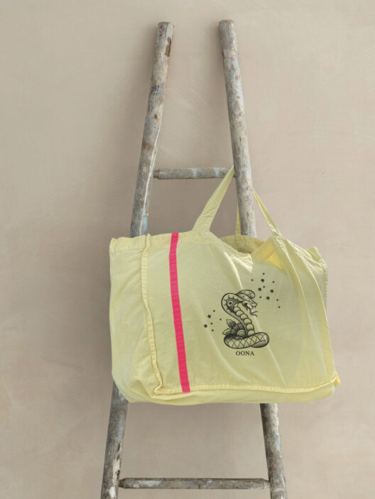 Gelbe Tasche mit Schlangendruck auf Leiter.