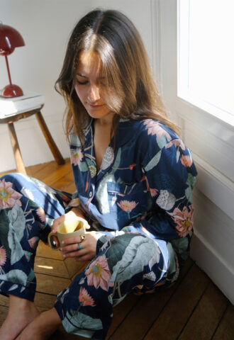 Femme en pyjama floral, boit du thé.