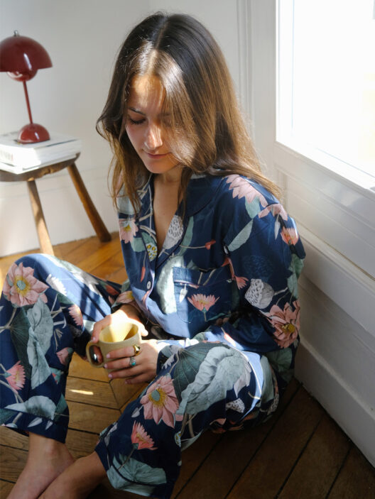 Femme en pyjama floral, boit du thé.