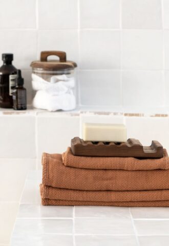 Savon sur serviettes avec accessoires de salle de bain.