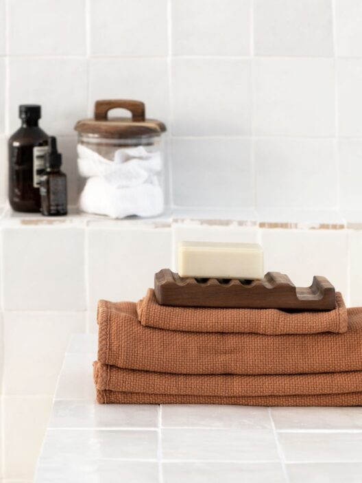 Savon sur serviettes avec accessoires de salle de bain.