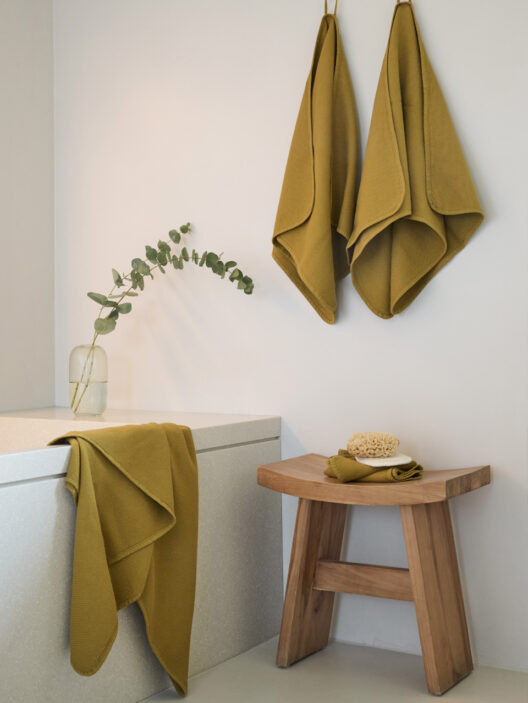 Serviettes jaunes accrochées dans salle de bain moderne.