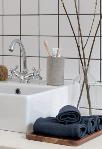 Lavabo blanc avec articles de toilette modernes.