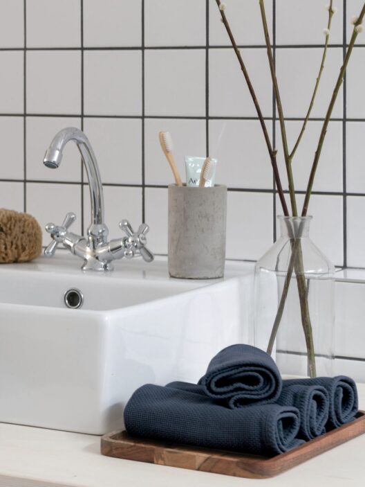 Lavabo blanc avec articles de toilette modernes.