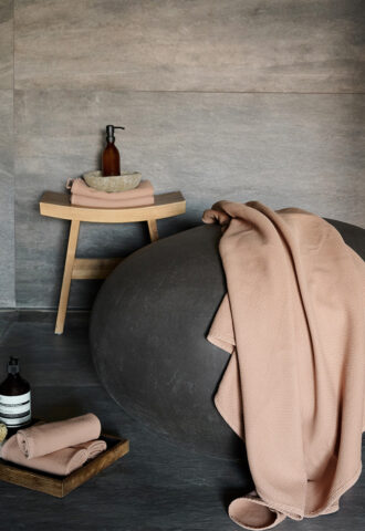 Salle de bain décorée avec accessoires et serviettes rose.