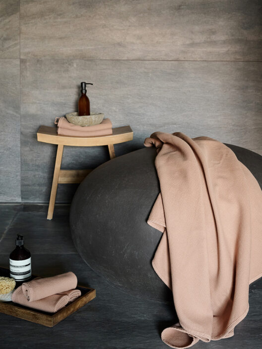 Salle de bain décorée avec accessoires et serviettes rose.