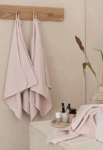 Salle de bain avec serviettes roses et plantes.