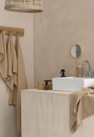 Salle de bains moderne avec lavabo et serviettes beiges.