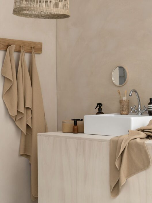 Salle de bains moderne avec lavabo et serviettes beiges.