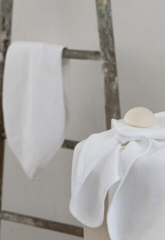 Serviettes blanches sur échelle en bois.