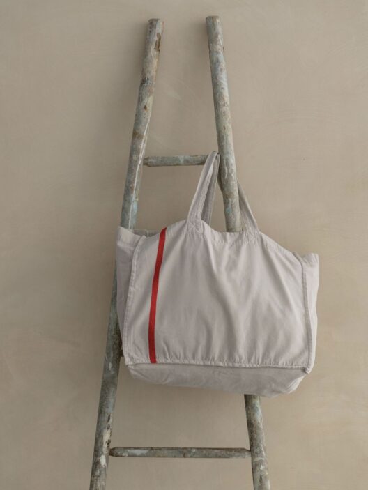 Sac blanc sur échelle en bois rustique.