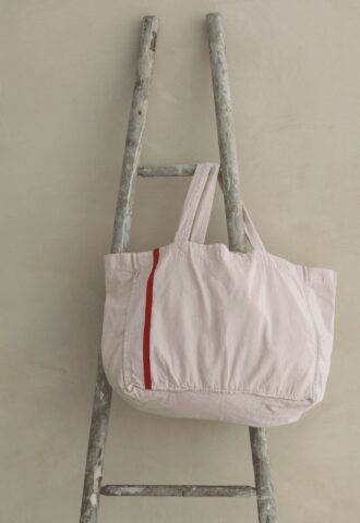 Sac blanc suspendu à une échelle rustique.