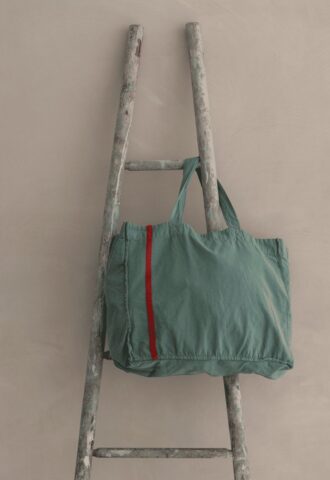 Sac vert sur une échelle en bois.