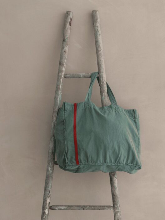 Sac vert sur une échelle en bois.