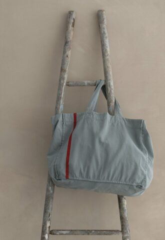 Sac bleu sur une échelle en bois.