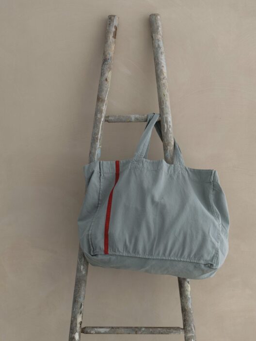 Sac bleu sur une échelle en bois.