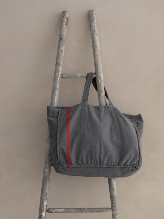 Sac gris sur échelle en bois.