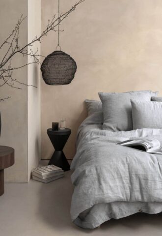 Chambre minimaliste avec lit gris et déco épurée.