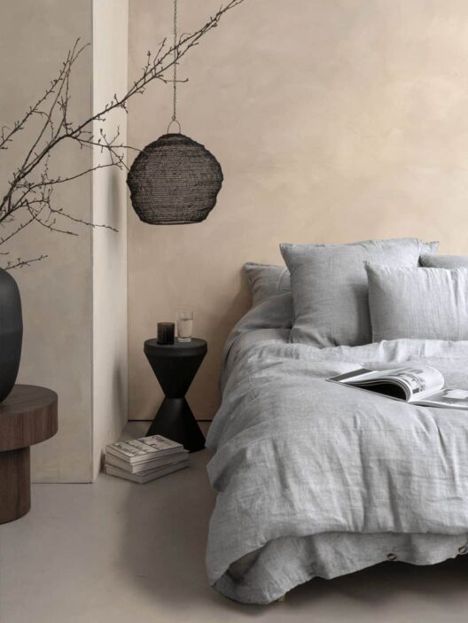 Chambre minimaliste avec lit gris et déco épurée.