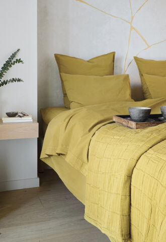 Chambre moderne avec literie jaune moutarde.