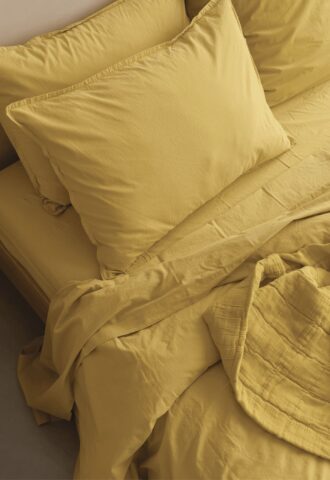 Ensemble de literie jaune sur lit.