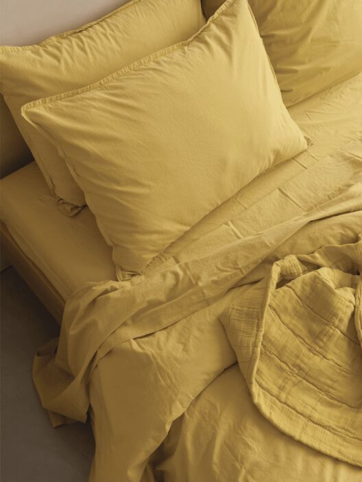 Ensemble de literie jaune sur lit.