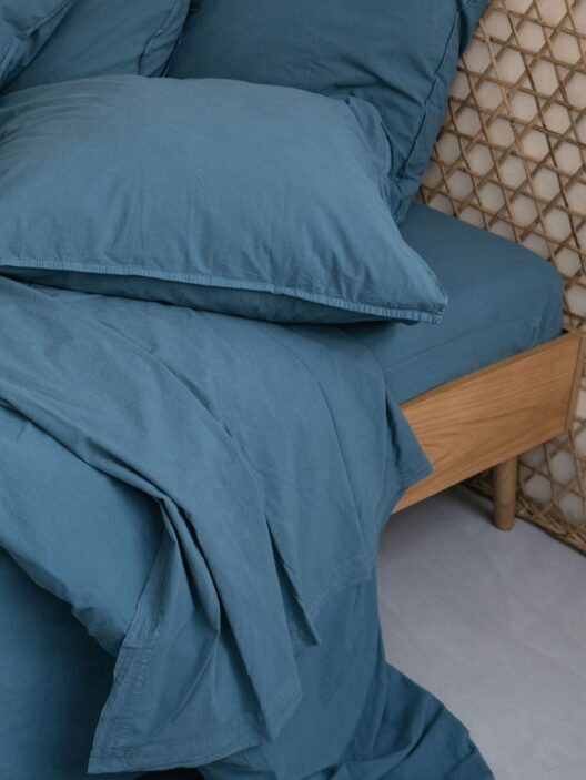 Lit avec linge bleu élégant et raffiné.