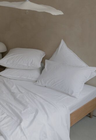 Lit avec oreillers et draps blancs.