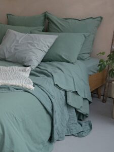 Lit vert avec oreillers et couvertures douces