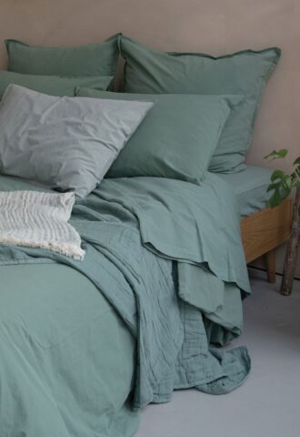 Lit vert avec oreillers et couvertures douces