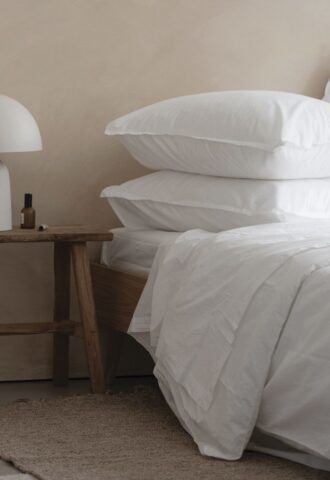 Chambre minimaliste avec linge de lit blanc.