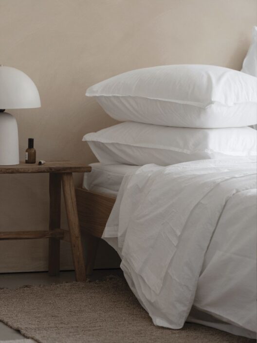 Chambre minimaliste avec linge de lit blanc.