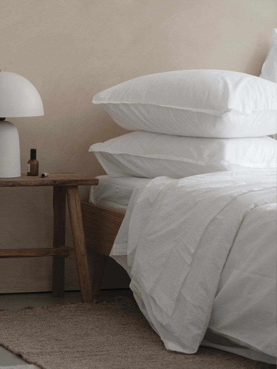 Chambre minimaliste avec linge de lit blanc.
