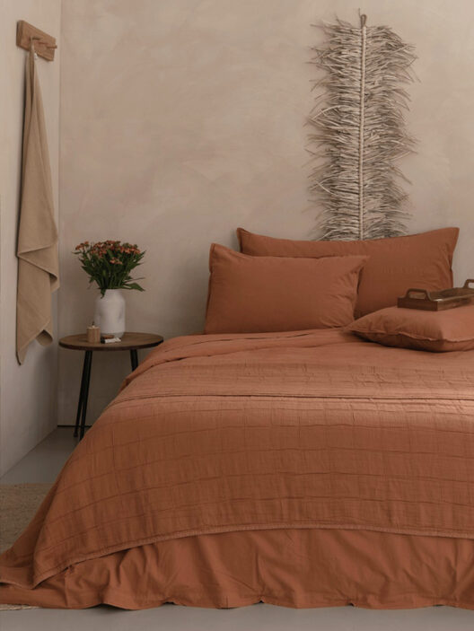 Chambre beige avec lit et décorations modernes.