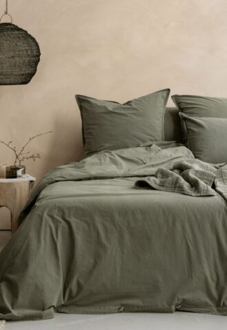 Chambre avec lit et décoration en lin naturel.