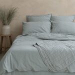 Lit avec linge bleu dans une chambre apaisante.