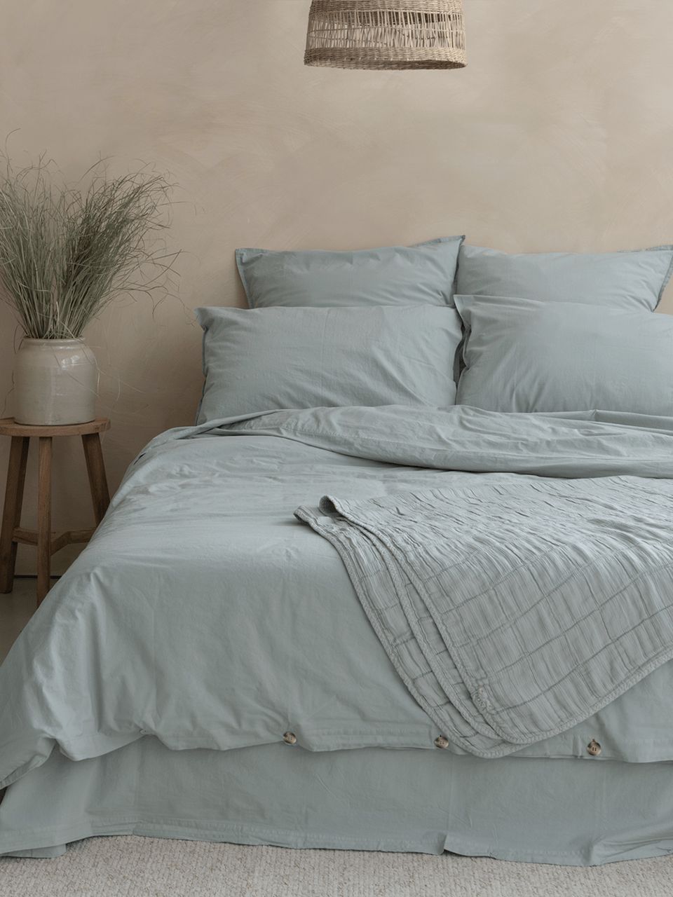 Lit avec linge bleu dans une chambre apaisante.