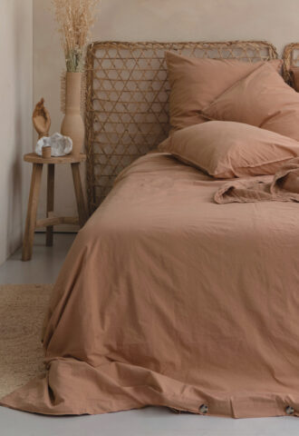 Chambre avec lit beige et déco naturelle.