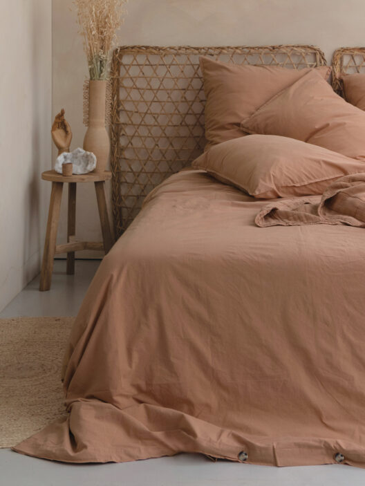 Chambre avec lit beige et déco naturelle.