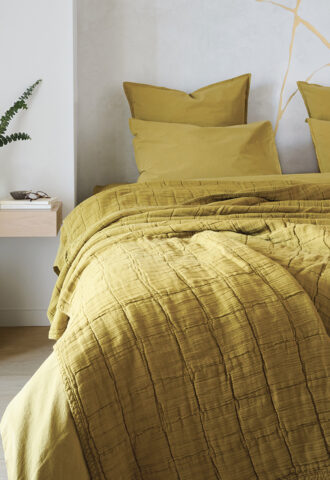 Chambre avec lit jaune, décoration minimaliste.