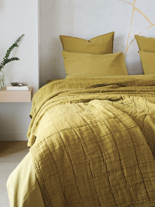 Chambre avec lit jaune, décoration minimaliste.