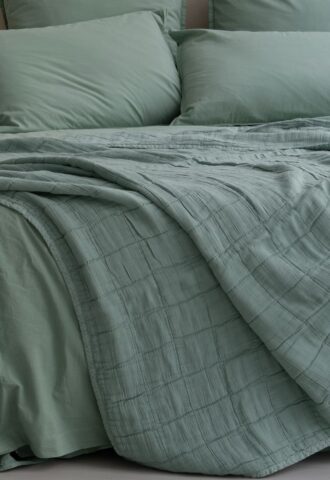 Lit avec draps verts élégants