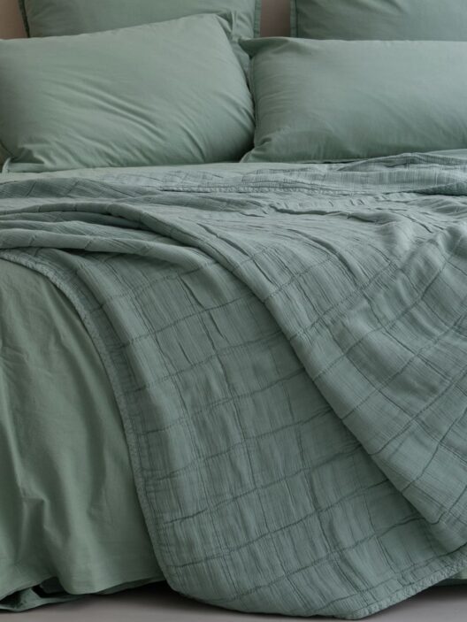 Lit avec draps verts élégants