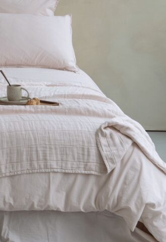 Lit avec tasse et croissant sur plateau.