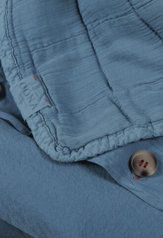 Détail d'une chemise bleue avec boutons.