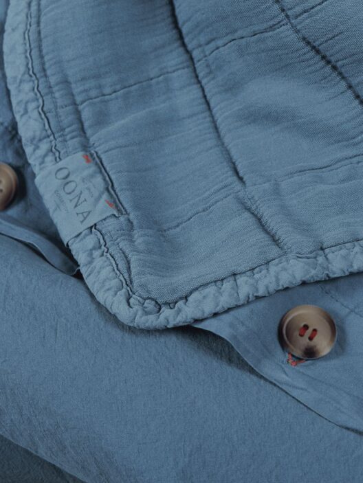 Détail d'une chemise bleue avec boutons.