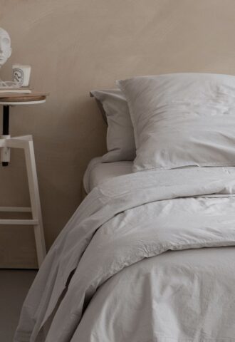 Lit avec oreillers et table de chevet minimaliste.